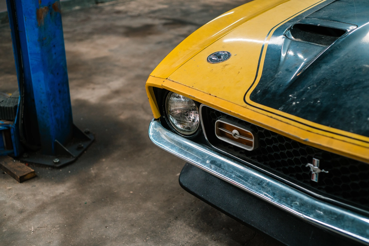 A 1971 Ford Mustang in an outdoor mechanic shop